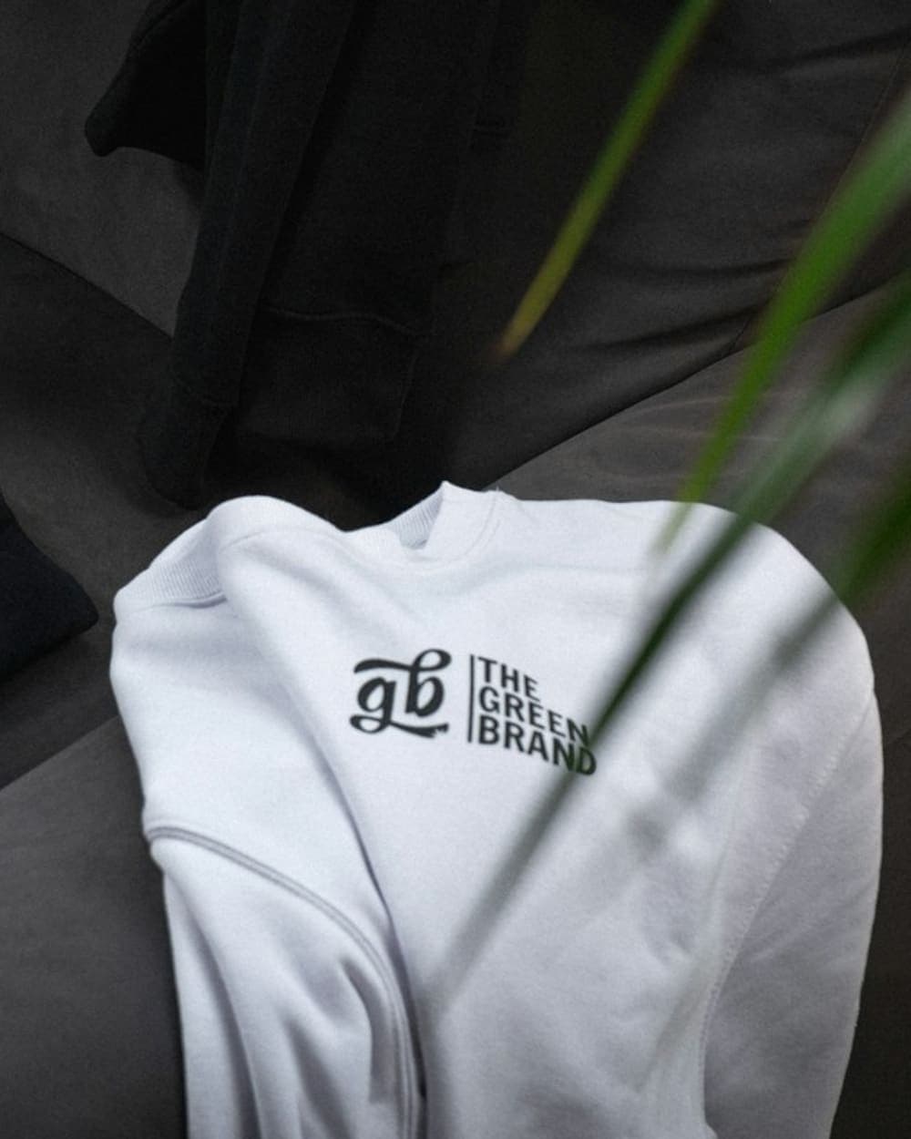 Pink cap on a black tee next to a white sweatshirt